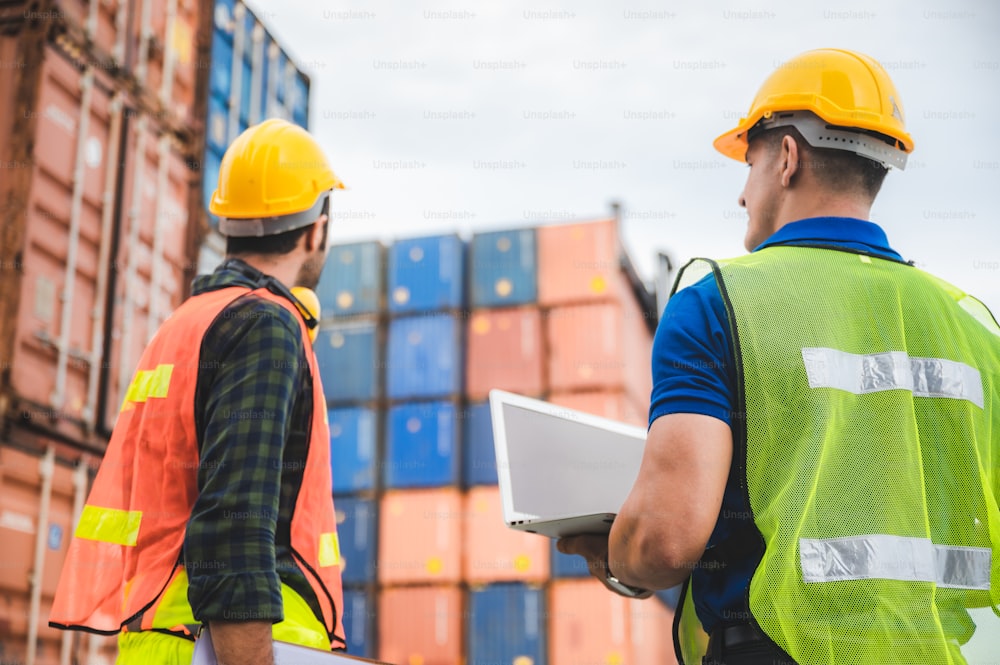 logistic worker teamwork and partner of foreman, engineer, and businessman working in an international shipping area, concept of business industrial and working in container yard to import and export