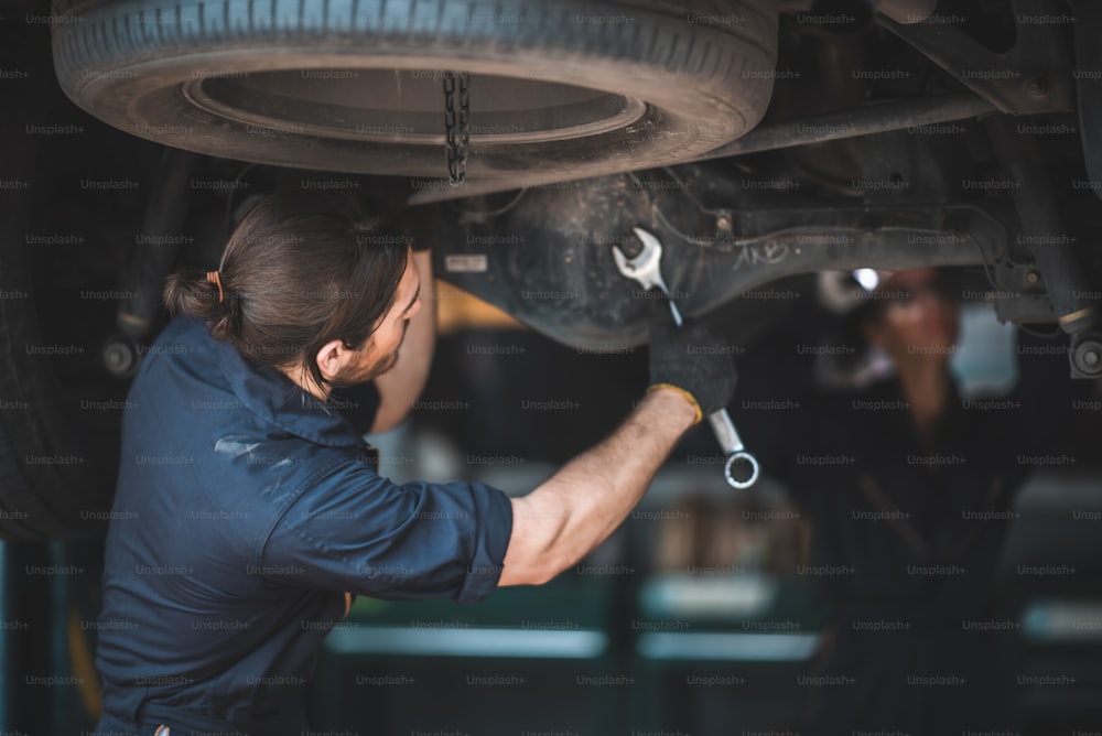 Officina per auto, riparazione e manutenzione di veicoli, automobili, tecnici, uomini, persone, officina per motori automobilistici e lavoro con utensili a motore