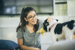 young girl playing a dog at home, cute woman person with her pet animal living from home, female are happy in lifestyle to relaxation to playing with puppy dog, stay home animal lover concept
