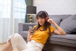 A young happy woman listening to music and relaxing at home