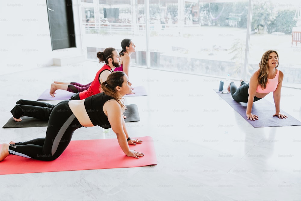 Young mexican people with instructor practicing yoga stretching exercises in Latin America