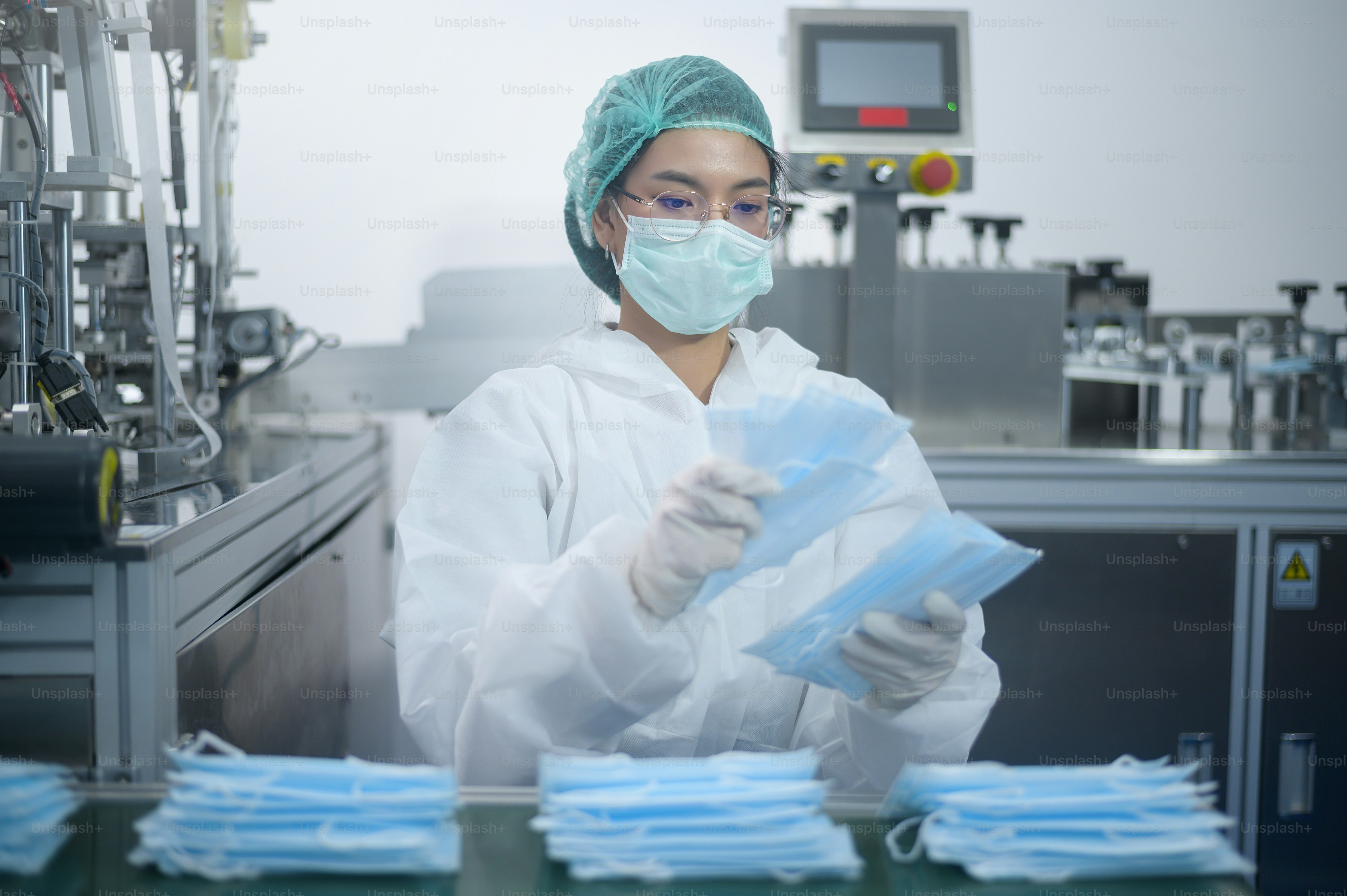 Workers producing surgical mask in modern factory, Covid-19 protection and medical concept.