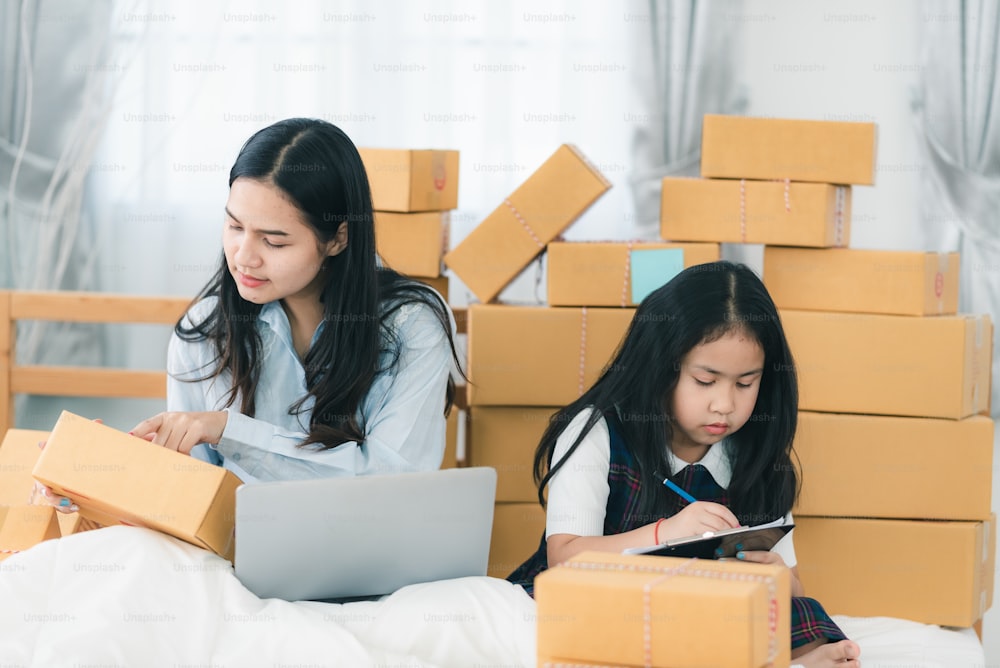 Mujer joven que empaca el producto en una caja de entrega, la empresaria propietaria de un negocio femenino está contenta con el negocio electrónico en línea en casa