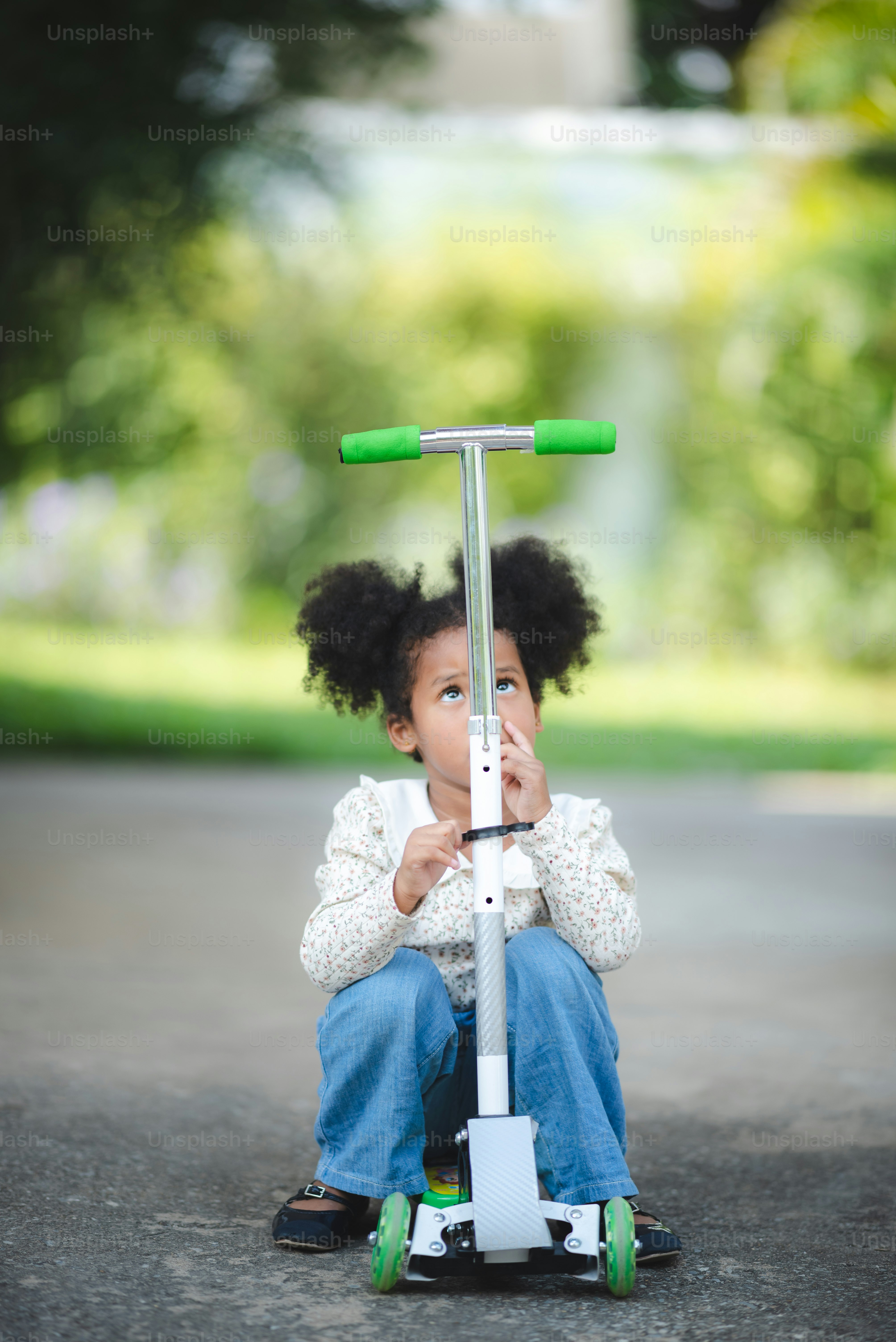Foto Niño afroafricano montando en scooter, jugando al aire libre en un ...