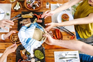 gruppo di amici che mangiano tacos messicani e cibo tradizionale, spuntini e persone mani sul tavolo, vista dall'alto. Cucina messicana