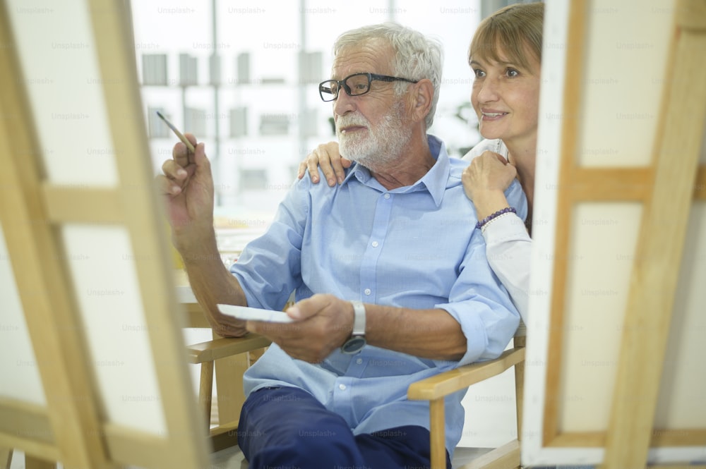Senior caucasian couple painting and relaxing at home