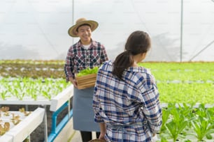 Una familia de granjeros feliz que trabaja en una granja de invernadero hidropónico, alimentos limpios y un concepto de alimentación saludable