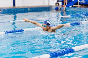 latin young man teenager swimmer athlete wearing cap and goggles in a swimming training in the Pool in Mexico Latin America