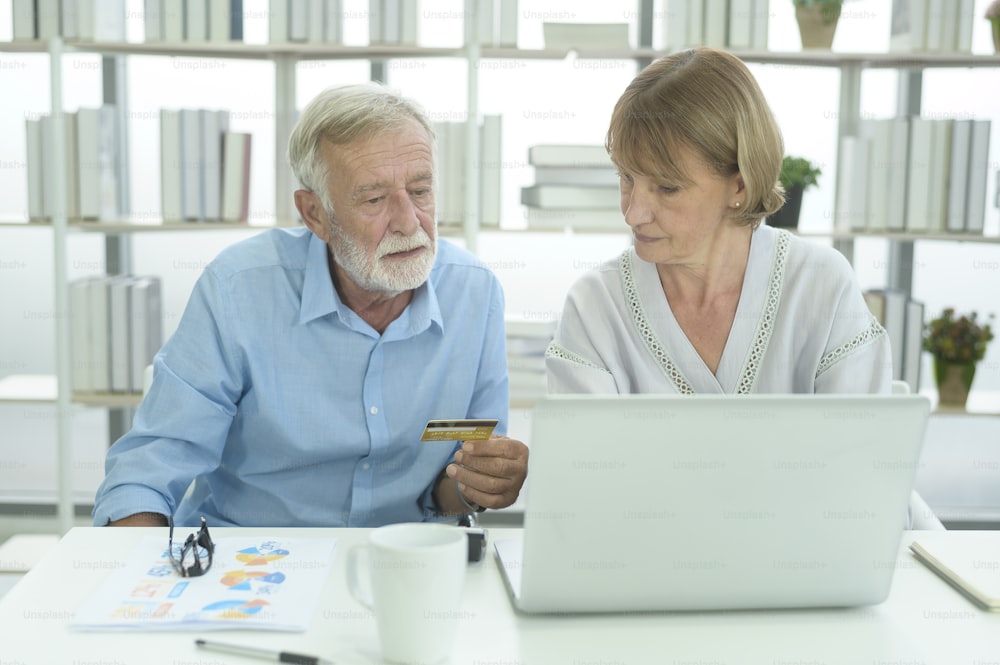 Persone anziane caucasiche che tengono la carta di credito, concetto di shopping online