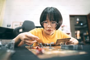 People hobbies lifestyle stay at home concept. Young adult asian woman playing board game on top table.