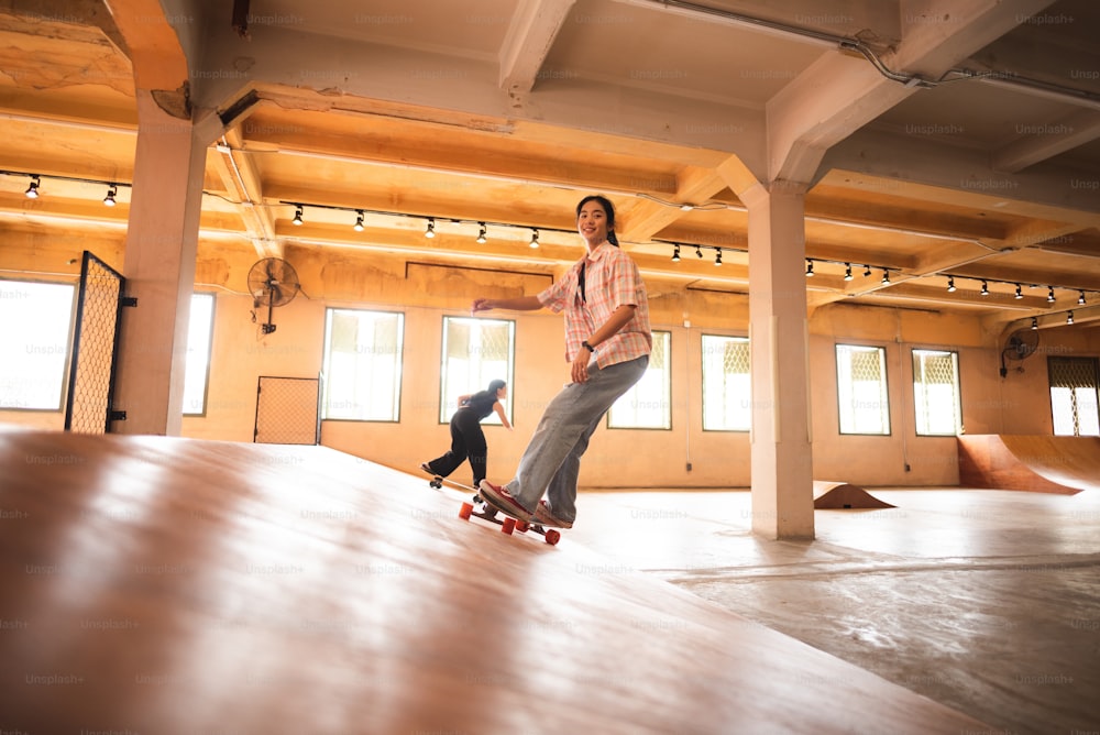 young woman person in sport skate lifestyle, happy teen girl having fun with skateboard in sport gym, hipster fashion urban activity trendy