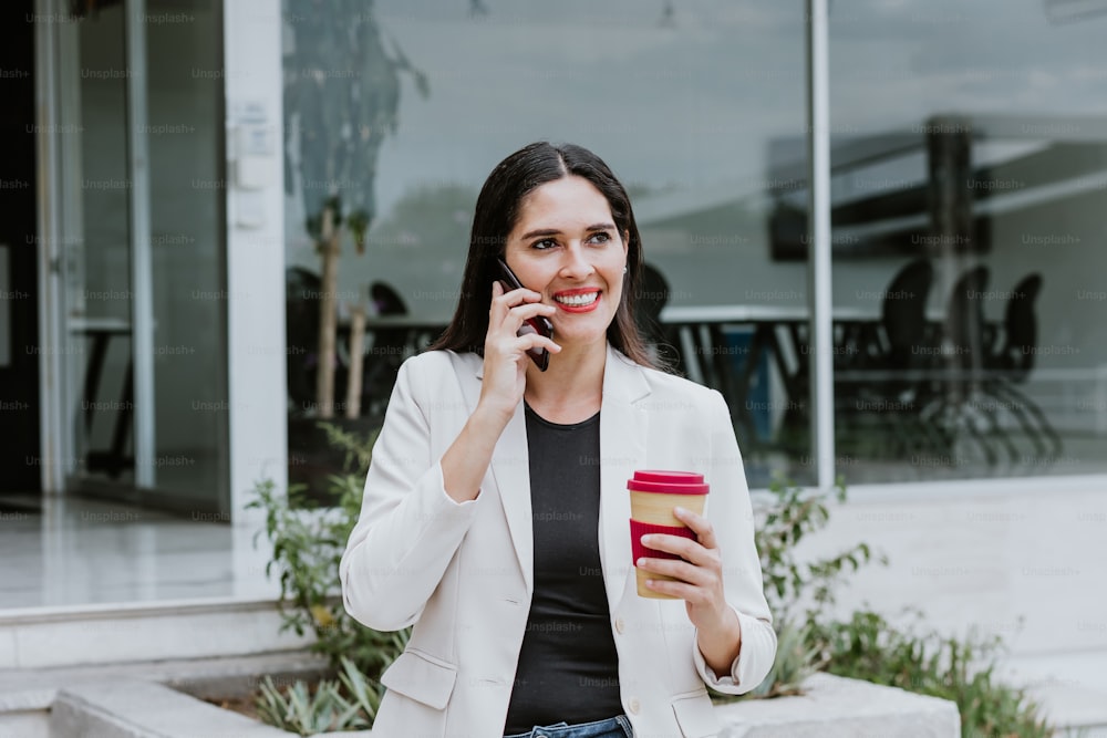hispanic business adult woman calling by mobile phone at the office terrace in Mexico Latin America