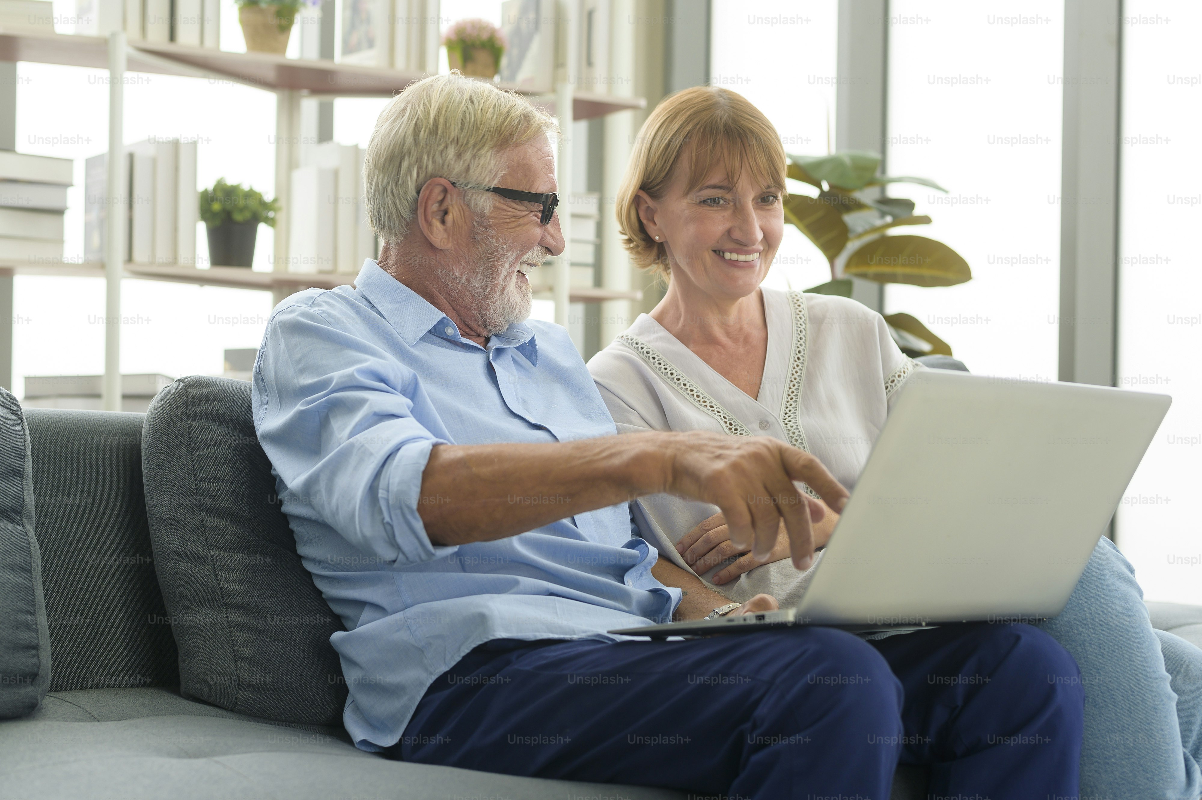Happy Caucasian senior couple using laptop at home