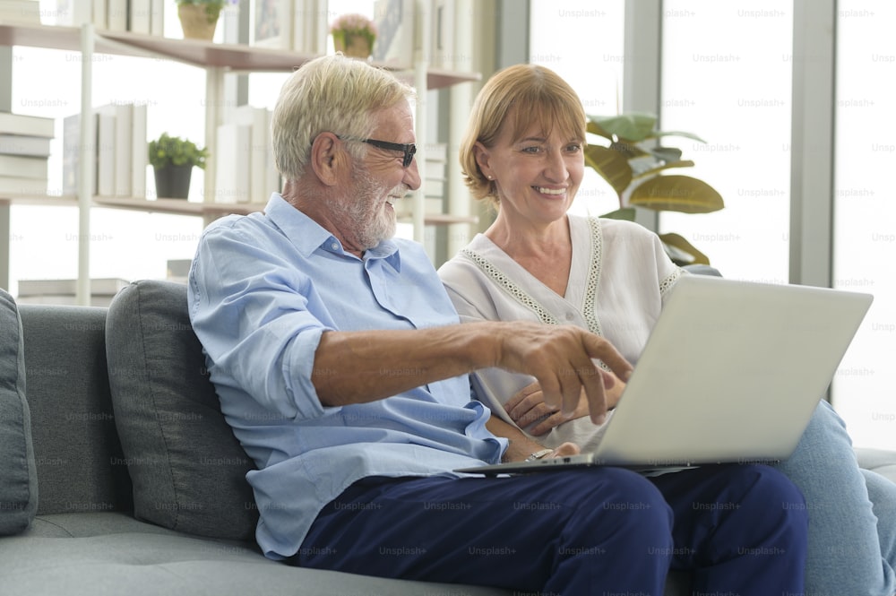 Happy Caucasian senior couple using laptop at home