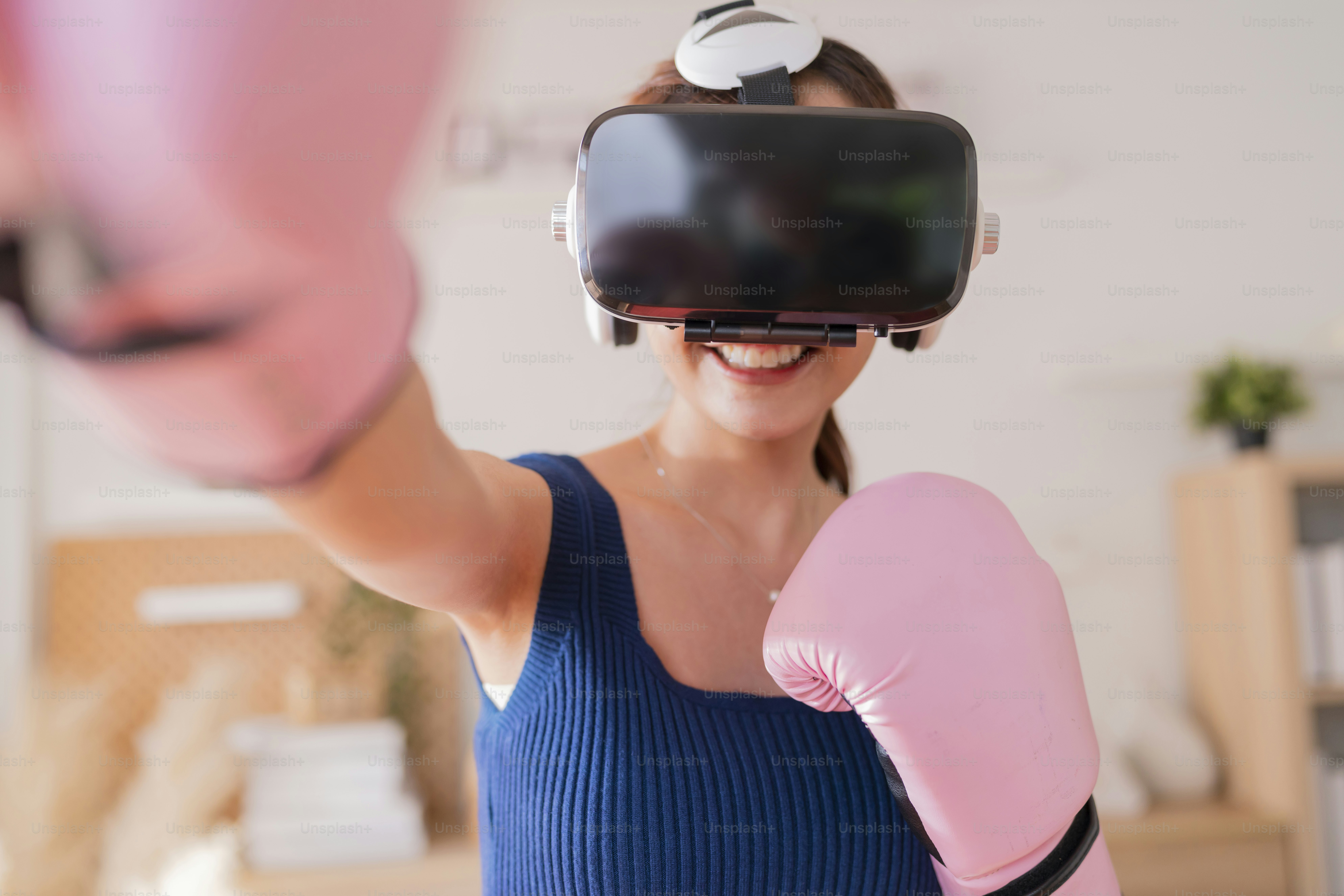 Virtual Metaverse Augmented Reality asian female adult working out boxing in VR headset aerobic training for boxing punch in virtual reality at living room home interior background