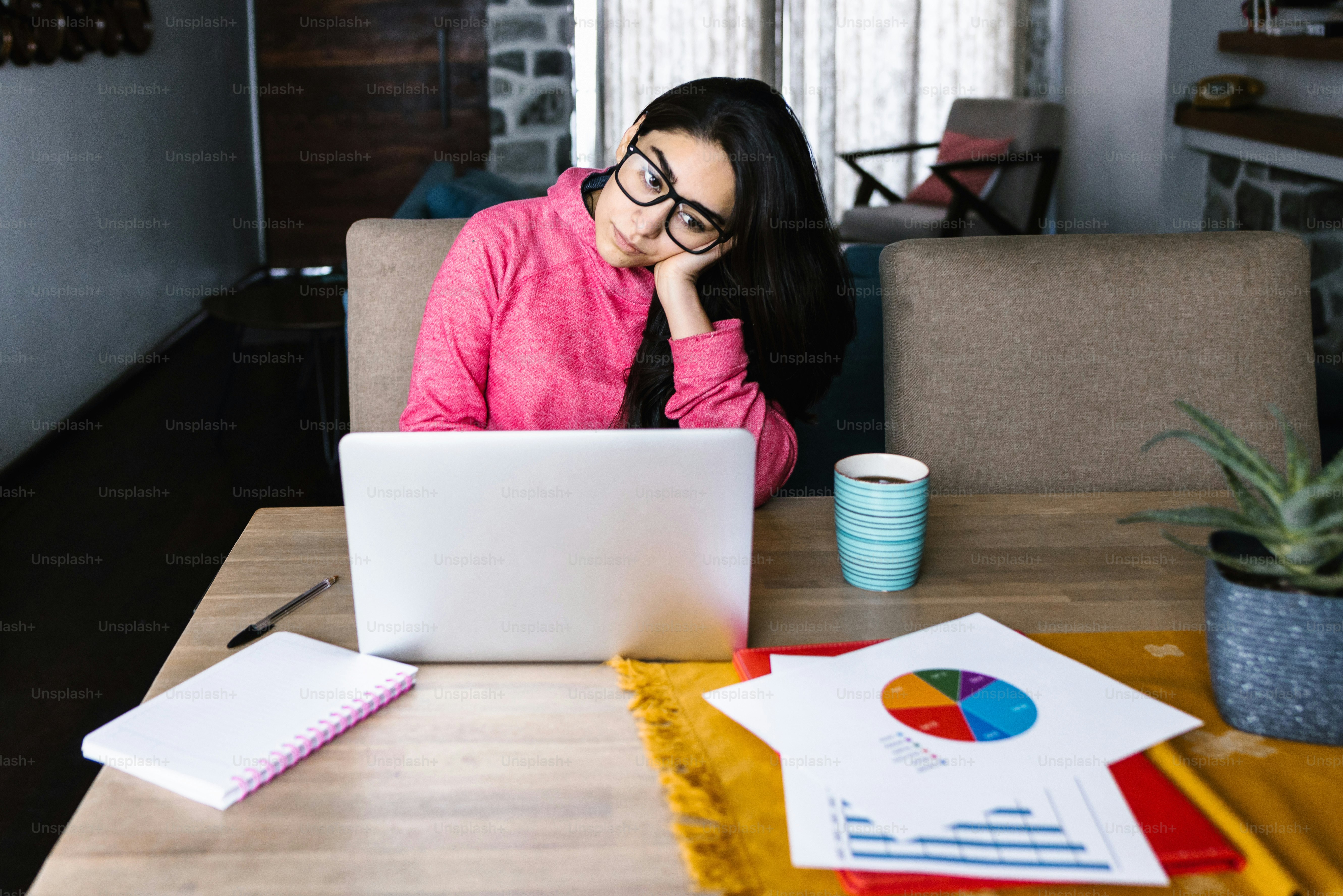 Latin woman in front of her laptop staring at the screen, bored, sleepy, tired in a home office concept in Mexico Latin America