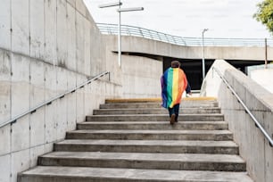 Mujer LGBT con una bandera arcoíris LGBTQ sobre sus hombros, concepto de mes del orgullo gay, orgullo lésbico, movimiento de concientización LGBT, inclusión no binaria y diversidad. Espacio de copia