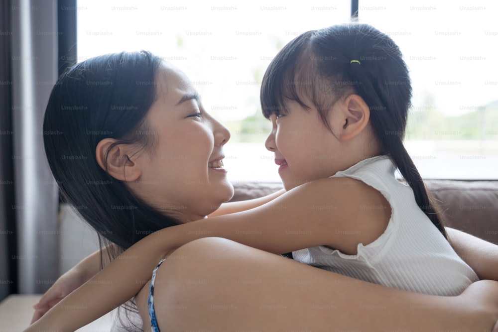 Asiatische Mutter und Tochter lächeln und schauen sich an. Happy love family Konzept