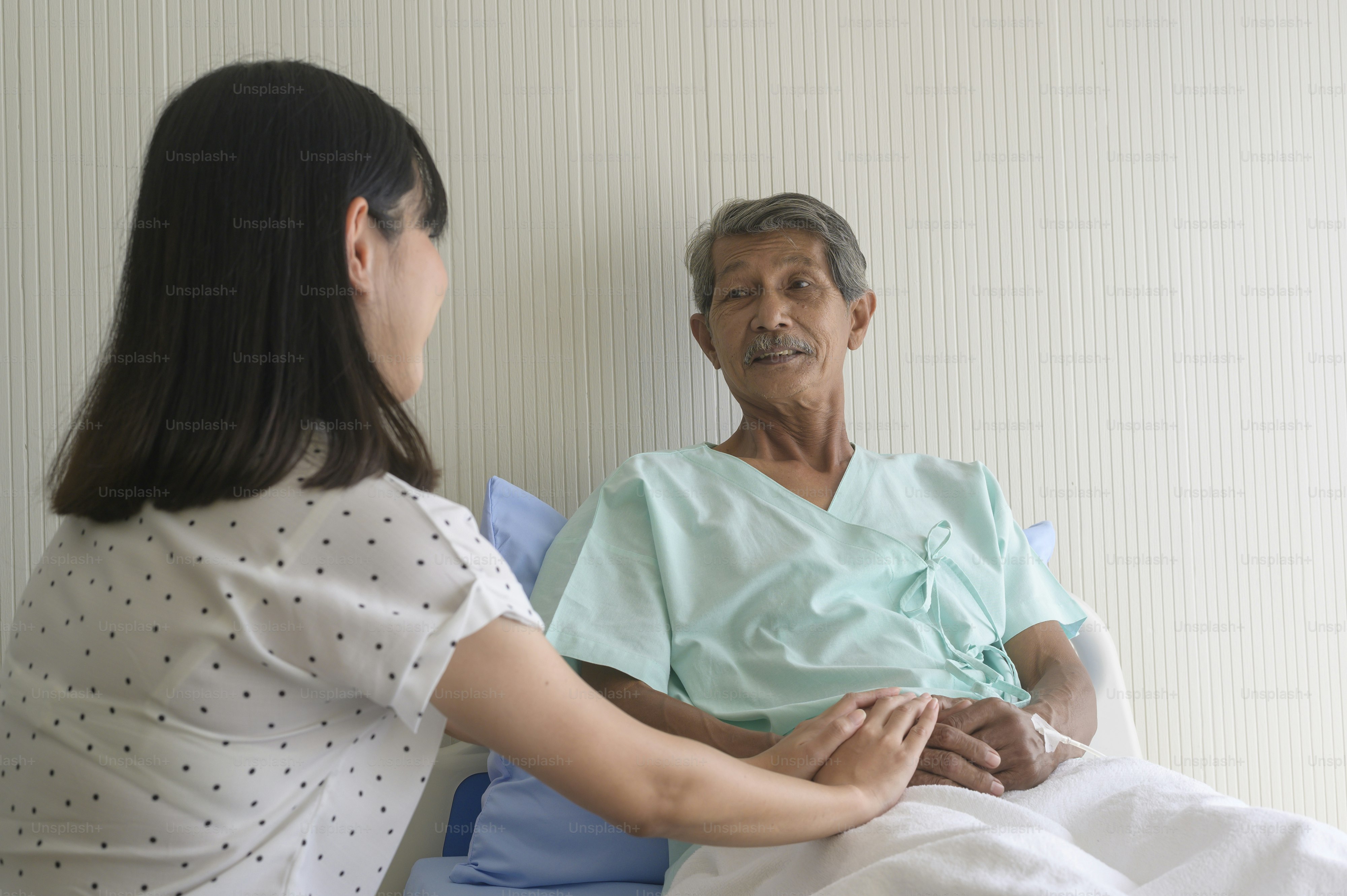 A young daughter visiting sick old father in hospital, healthcare and medical concept