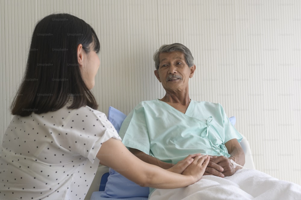 Eine kleine Tochter besucht kranken alten Vater im Krankenhaus, Gesundheits- und Medizinkonzept