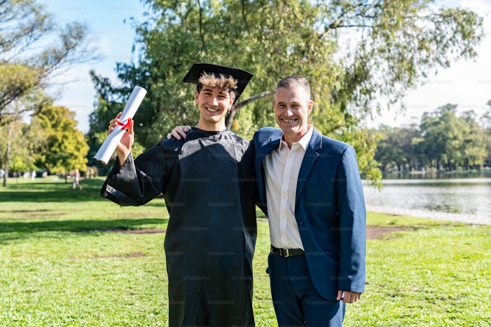 Portrait of a happy caucasian graduated young man with his father on his graduation day.  They are both looking at camera