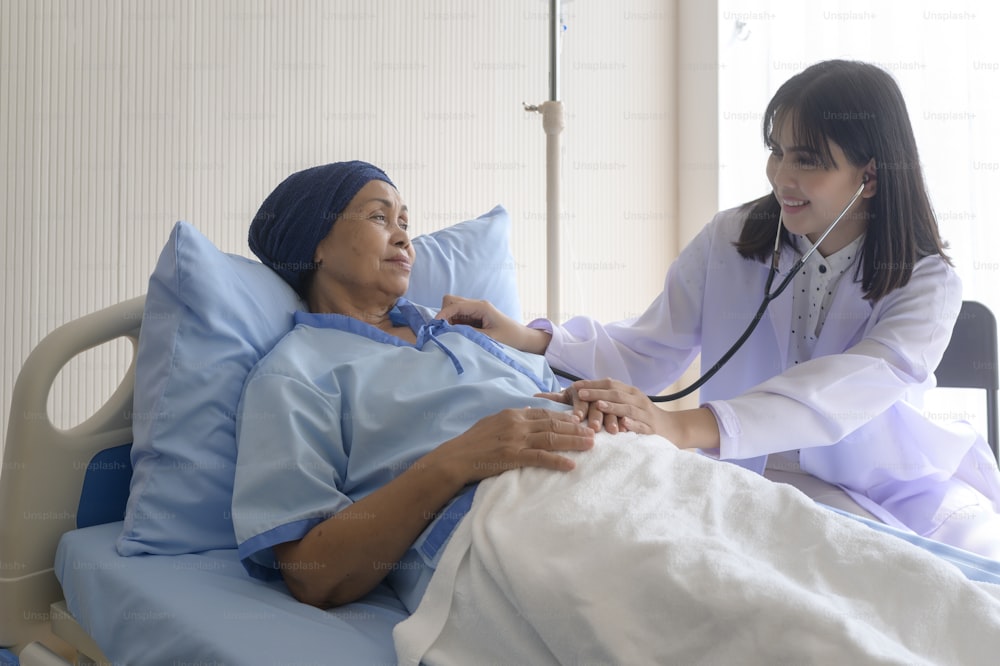 Cancer patient woman wearing head scarf after chemotherapy consulting and visiting doctor in hospital..