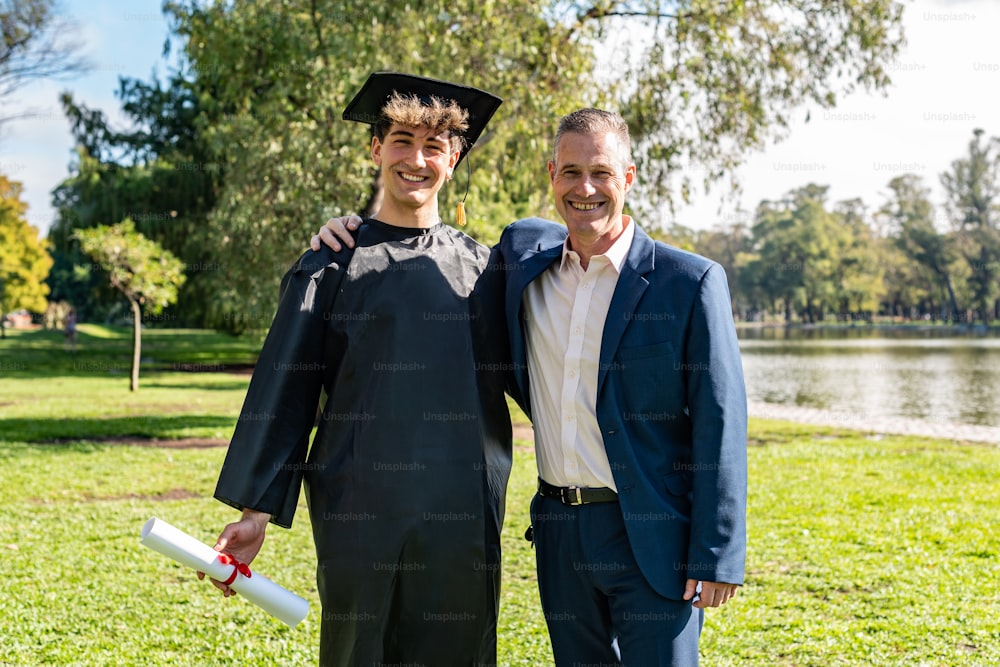 Portrait of a happy caucasian graduated young man with his father on his graduation day.  They are both looking at camera