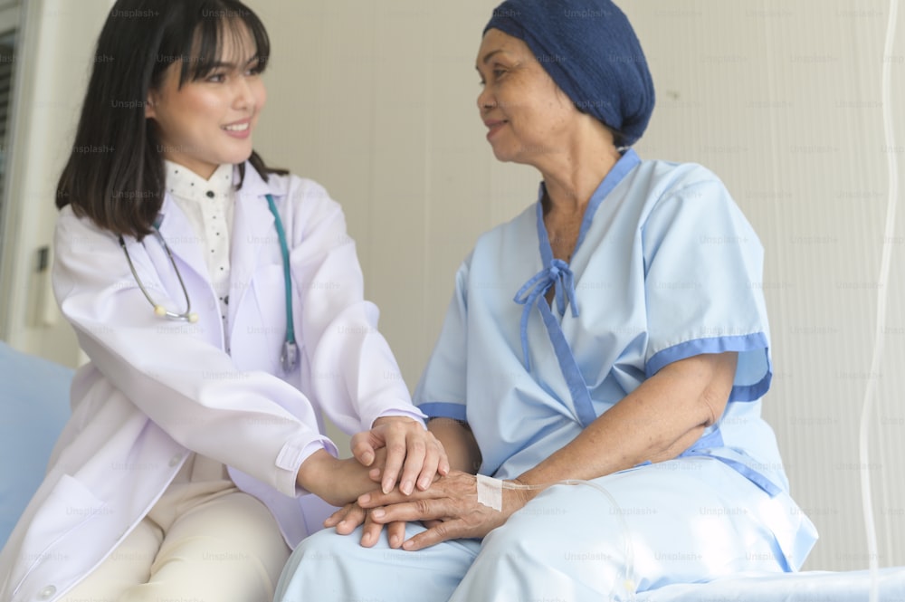 Arzt, der die Hand eines älteren Krebspatienten im Krankenhaus, im Gesundheitswesen und im medizinischen Konzept hält