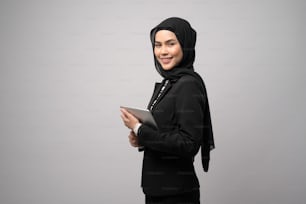 Portrait of young beautiful muslim businesswoman  is holding tablet over white background studio