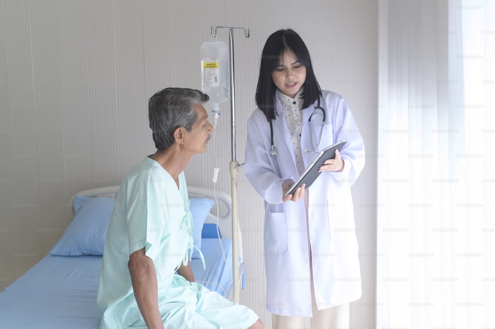 Paciente asiático sênior do sexo masculino está consultando e visitando o médico no hospital.