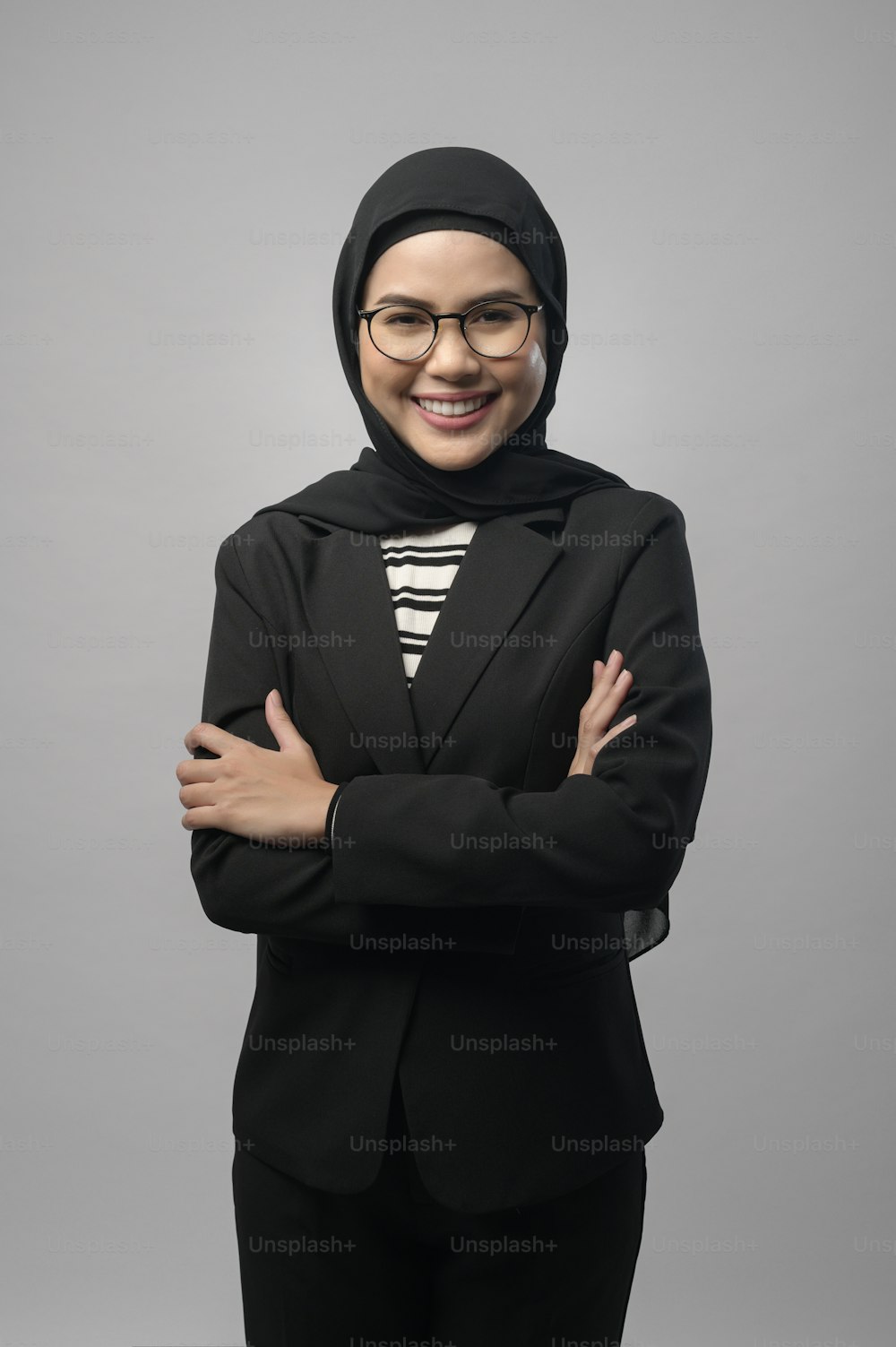 Una bella donna musulmana che indossa occhiali su sfondo bianco studio