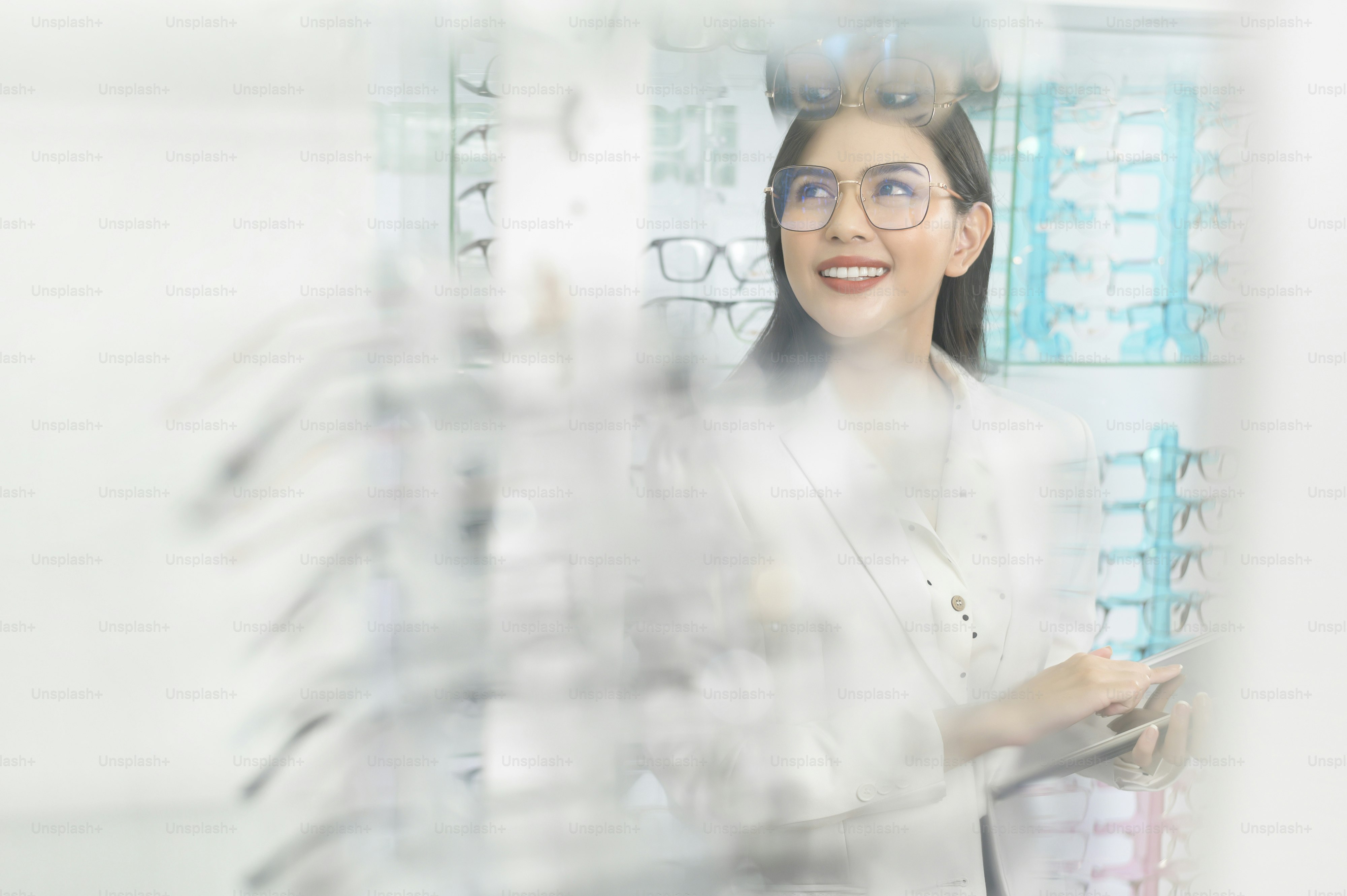 A Young ophthalmologist holding tablet in optical center, eyecare concept.