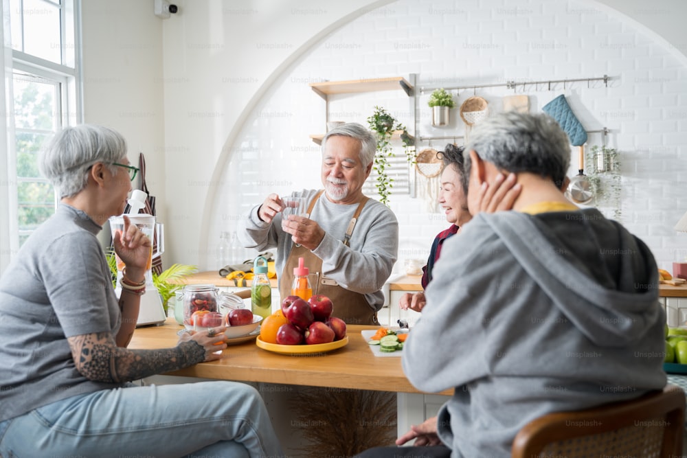 Gruppo di amici anziani asiatici che fanno succhi di frutta per gli amici da bere in frutta e verdura kitchen.colored. Mangiare sano