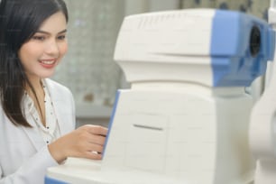 A Young ophthalmologist doing a visual test for customer using autorefractor in optical center, eyecare concept.