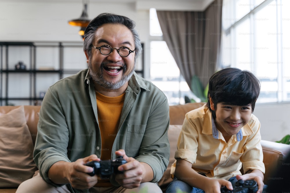 Hijo y papá jugando videojuegos en casa