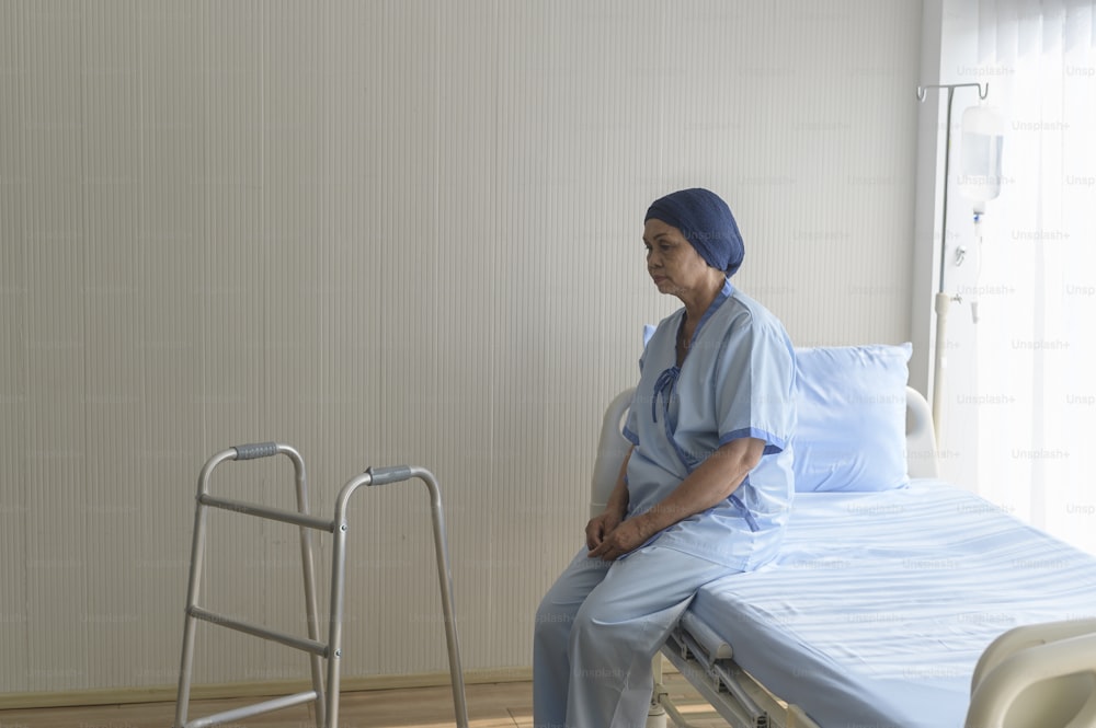 Portrait of senior cancer patient woman wearing head scarf in hospital, healthcare and medical concept
