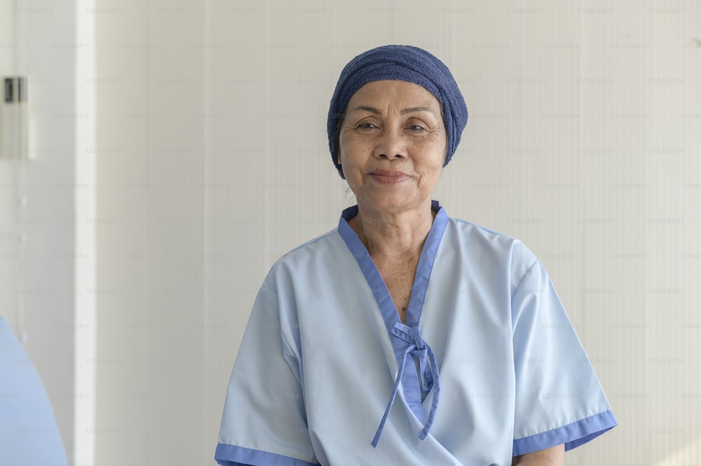 Portrait of senior cancer patient woman wearing head scarf in hospital, healthcare and medical concept