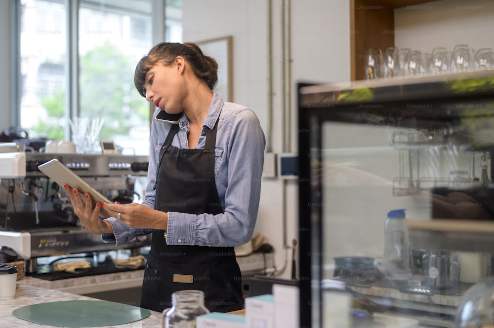 Young service minded barista woman working in coffee shop