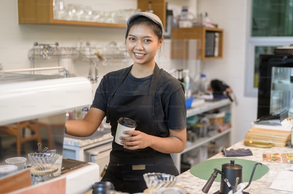 Junge serviceorientierte Barista-Frau, die im Café arbeitet