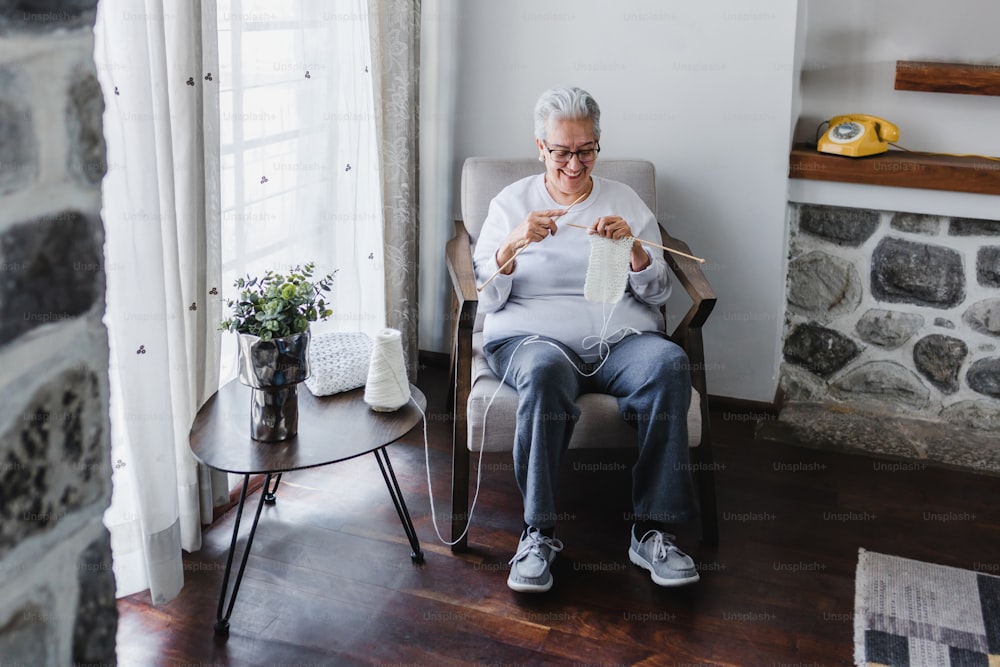 Abuela hispana tejiendo en casa en México América Latina