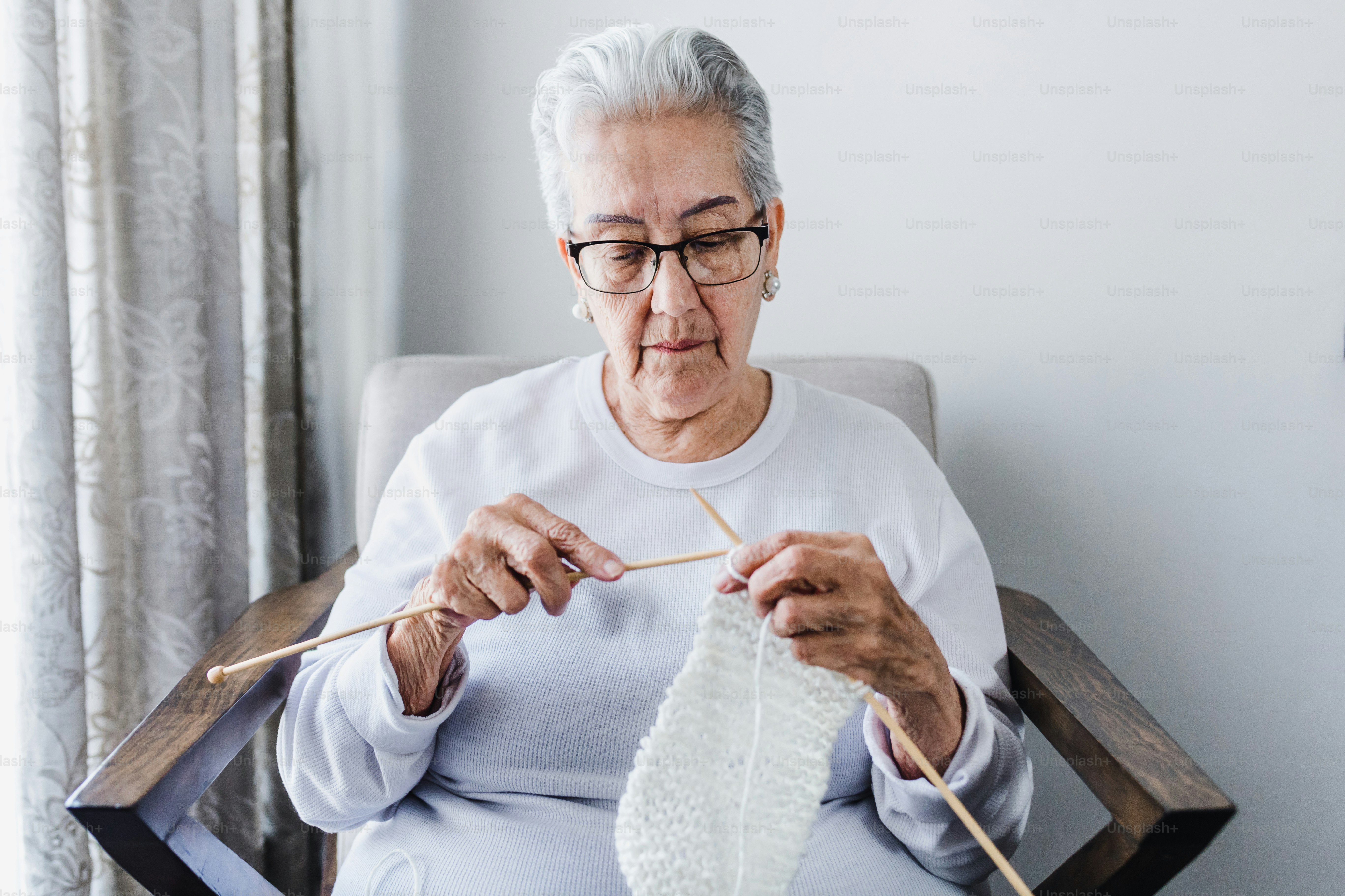 hispanic Grandmother knitting at home in Mexico Latin America