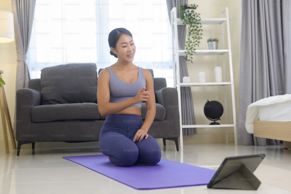 A Professional yoga coach teaching online training class to students during live streaming on social media, healthcare concept