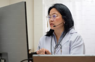 Il medico della donna asiatica visita la videochiamata del paziente online diagnostica il sintomo in clinica