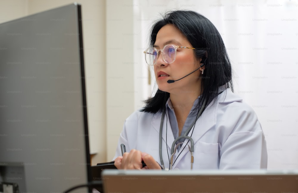 アジアの女性医師が患者を訪問し、ビデオ通話をオンラインで診断し、クリニックで症状を診断します