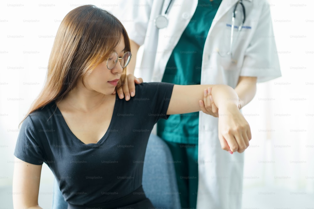 아시아 여성 물리 치료사는 환자의 운동을 감독합니다.