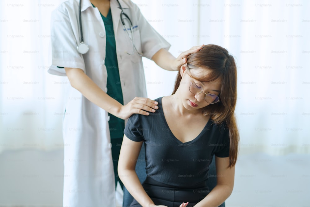 Physiotherapeut kümmert sich um einen Patienten mit Rückenschmerzen in einer Klinik.