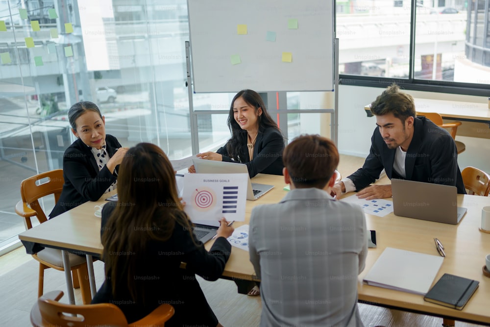 Rencontre d’hommes d’affaires asiatiques qui s’engagent dans le travail. Équipe d’affaires créative assise travaillant ensemble au bureau.