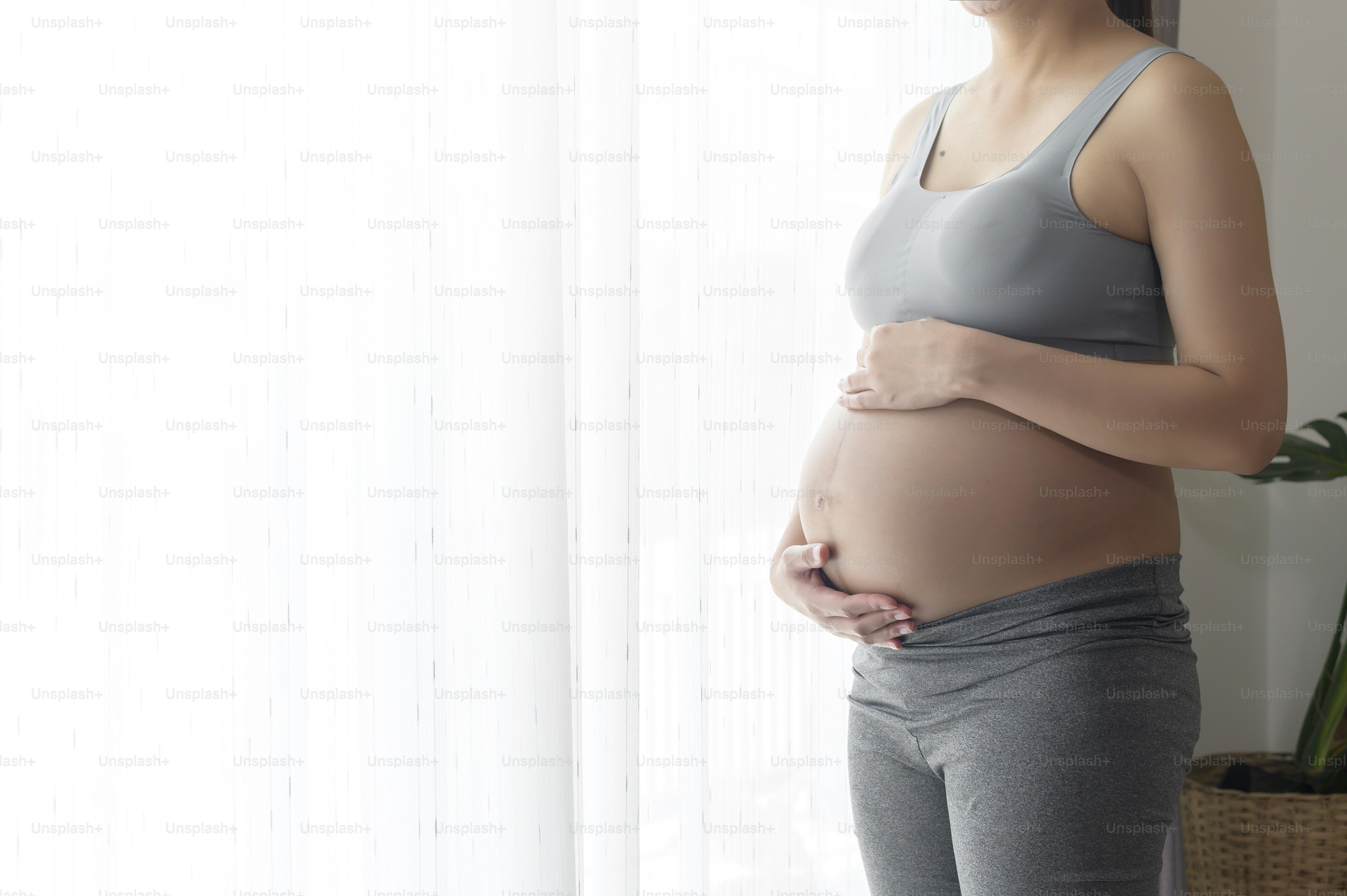 Young beautiful pregnant woman at home, maternity and pregnancy care concept
