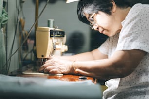 재봉틀로 천을 만드는 동남아시아 노인들. 베이비 붐 세대는 성숙한 재택 근무 개념입니다. 솔직한 초상화의 삶의 순간은 진정한 사람들입니다.