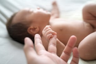 Chiusura della mano che tiene il dito del bambino appena nato